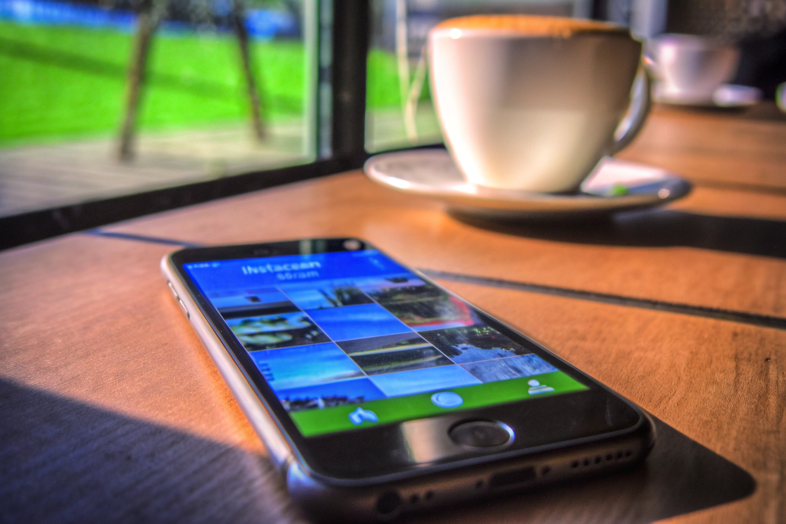 Eine Person, die Instagram auf ihrem Smartphone verwendet, während sie in einem Café sitzt. Instagram-Nutzung im Café