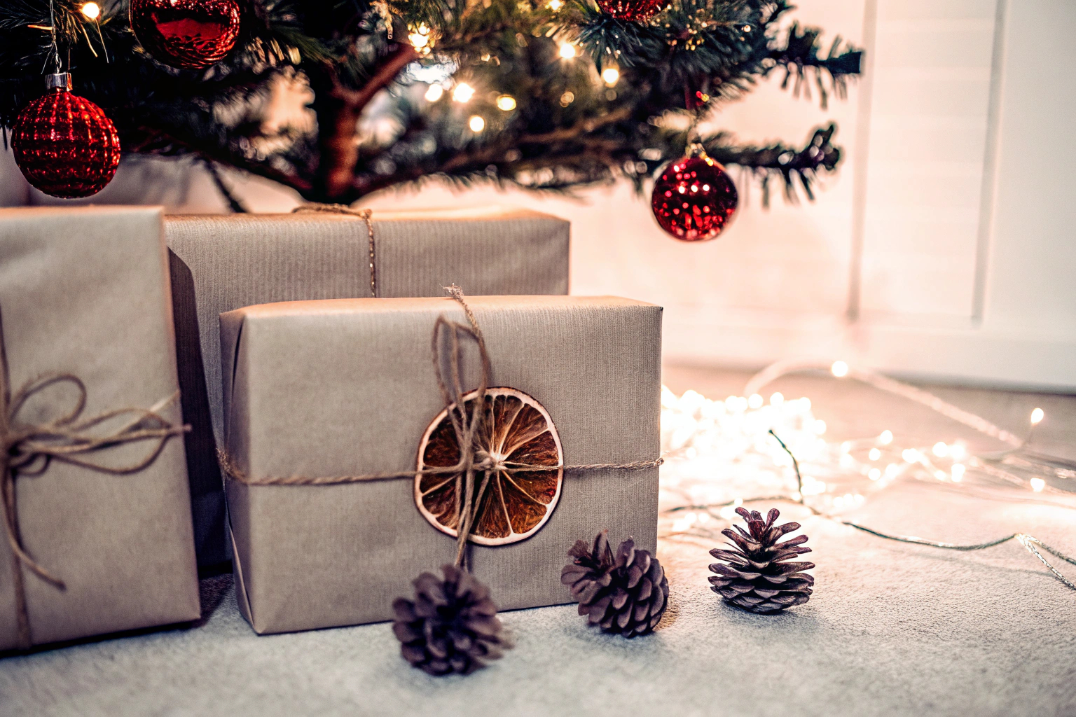 Nachhaltige Geschenkverpackungen unter einem Weihnachtsbaum